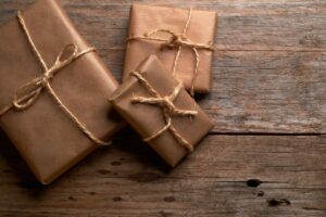 Christmas gifts wrapped in brown kraft paper and twine on a wooden table