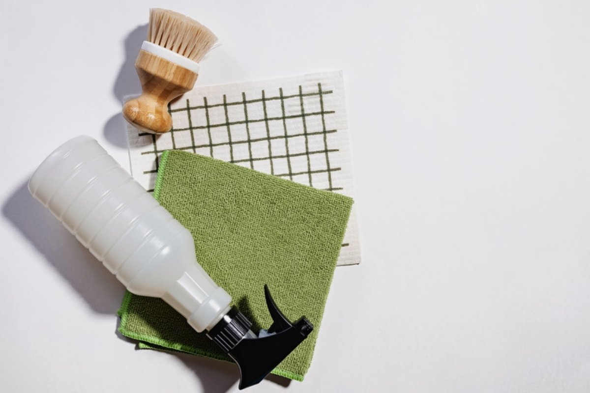 Reusable cloths, a wooden dish brush and a refillable spray bottle for eco-friendly cleaning