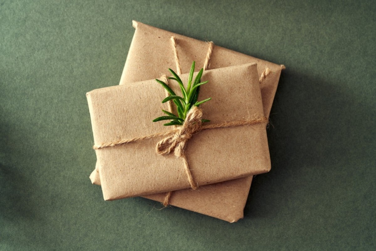 Gifts wrapped in brown kraft paper tied with twine and topped with a sprig of rosemary